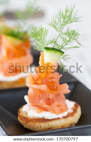 Smoked salmon and sour cream appetizer, garnished with dill. Close-up view