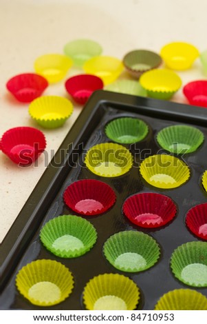 Mini cupcake tin with vibrant colorful cupcake papers ready to be filled with batter
