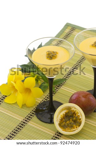 Two Glasses with passion fruit mousse and fresh, cut passion fruit, isolated on white