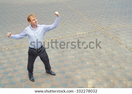 Image of a businessman showing his physical strength and standing on the street. On the face of a businessman successful look.