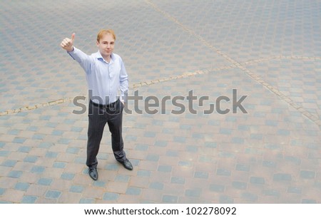 Image of a contented businessman standing on the street. On the face of a businessman successful look.