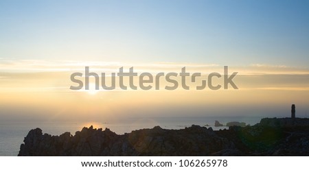 sunset in Pen Hir, on which stands a monument in the form of a cross with a stone carved on it the figures of men and women figure, dedicated to the Battle of the Atlantic in World War II, Bretagne.