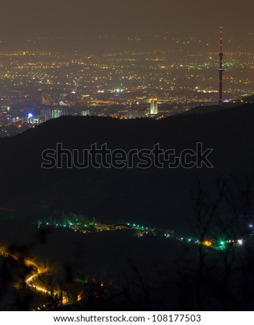 Image top night lighting of the city of Almaty, in the foreground which depicts the road to the famous place in the mountains - Medeo. Kazakhstan.