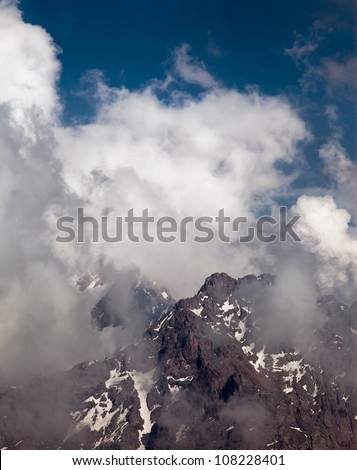 Picture a landscape of snow tops of mountains in the background of the beautiful white clouds. Switzerland.