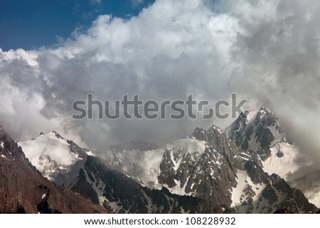 Picture a landscape of snow tops of mountains in the background of the beautiful white clouds. Switzerland.