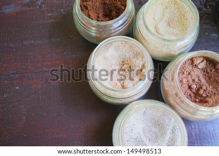 Image of the top view of open jars filled with cocoa, tea with lemon, tea with ginseng, ginger tea in Bali Plantage, Indonesia.