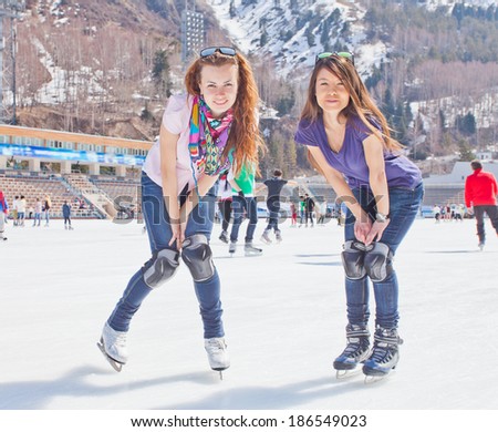 Image of group of teenagers on the ice skating at the Medeo