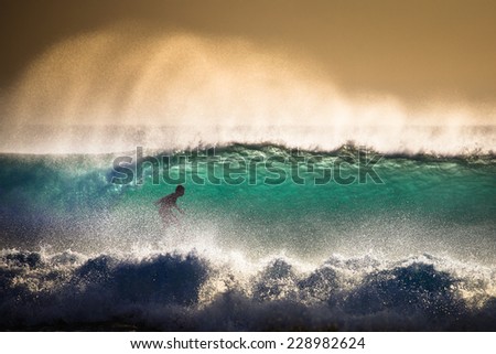 Surfer on Blue Ocean Wave in Bali Indonesia Focus on foreground Surfer on Blue Ocean Wave in Bali Indonesia Focus on foreground