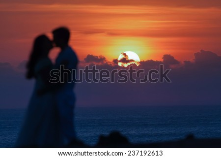 First date of a couple at background silhouette. Focus at the sun