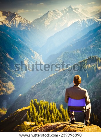 businessman at the top of mountain, thinking about future plans.
