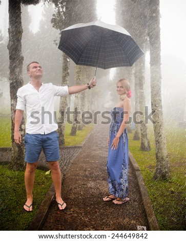 Couple travelling to Asia with umbrellas in bad weather