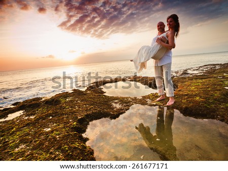 wedding couple at Hawaii, husband holding on hands his bride