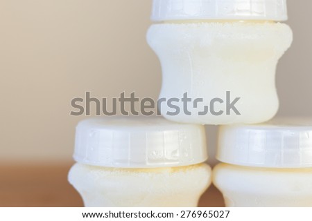Baby bottle with milk, on the background of a lot of full bottles of breast milk. Mother\'s milk - the most healthy food for newborn