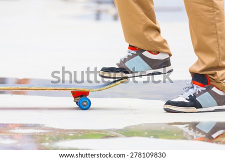 skateboarder riding a skateboard on the street or in the park, close-up athletic shoes - sneakers