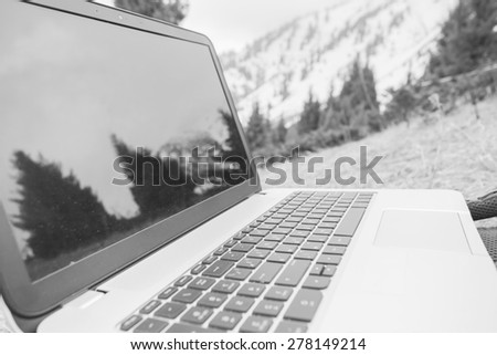 someone uses laptop remotely with 3g or 4g network wireless at mountain, black and white edition