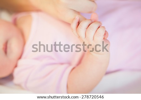Baby holding mother finger, there is concept or idea of care, family and happiness at the home, like mother caring for newborn