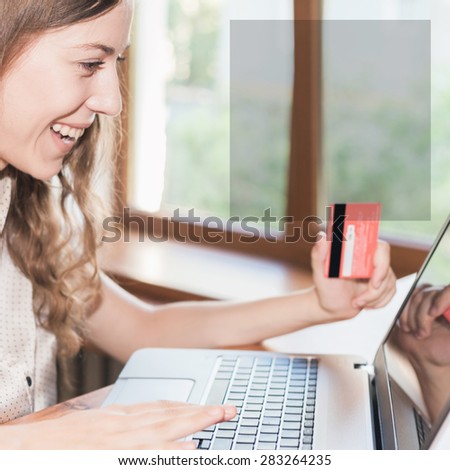 Beautiful surprised and successful woman holding credit card, and make online payment by plastic card through Internet Banking. There is a square frame for text or copy space