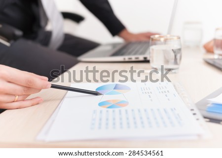 close-up graph and charts on the table during business meeting at office. Officer reports about financial achievements for a seminar