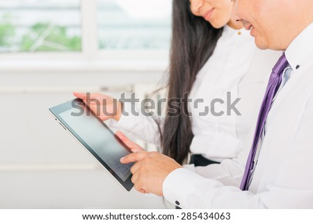 close-up image of business people dressed in white using tablet pc at office
