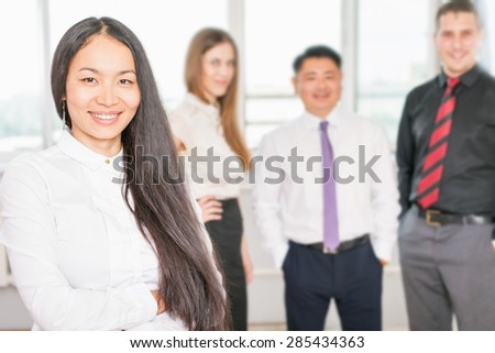 Successful asian business woman with magnificent long hair and business team at background. Symbolizes successful corporation or company where achieve success for intelligent and beautiful women