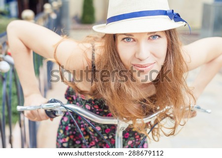 Closeup happy pretty woman travel to Paris by city bicycle, she looks amazing and looks into the camera