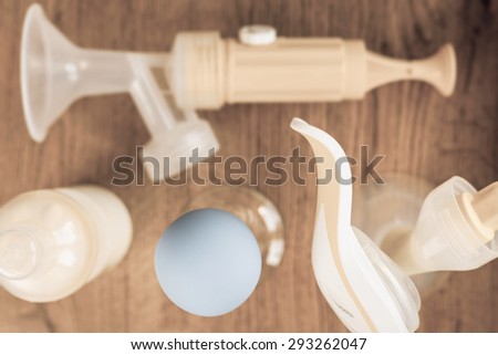 Background of manual and automatic breast pump, baby bottle with milk. Mothers breast milk is most healthy food for newborn baby. Selective focus
