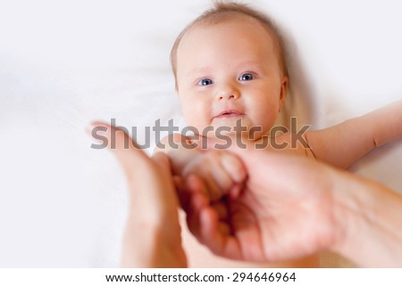 Mother makes massage for happy baby, apply oil on the hands, with white background and large copy space for any text