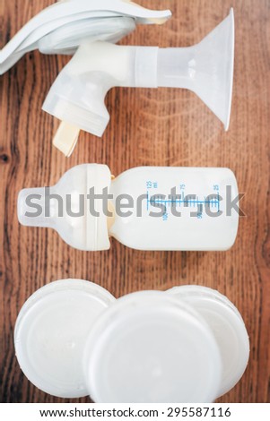 Background of manual breast pump and baby bottle with milk. Mothers breast milk is most healthy food for newborn baby. Top view.