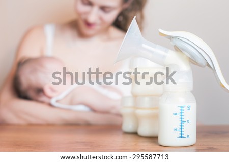 Manual breast pump and mother feeding at background, mothers breast milk is the most healthy food for newborn baby
