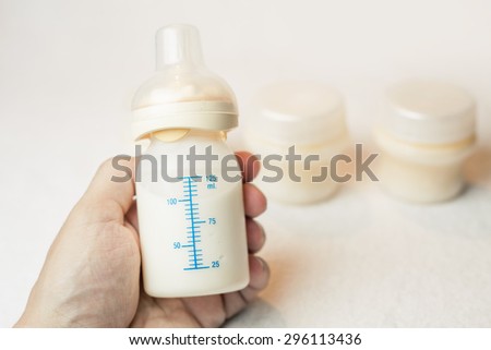 Father holding a baby bottle with breast milk for breastfeeding, mothers breast milk is the most healthy food for newborn baby