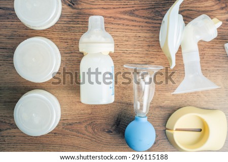 Background of manual and automatic breast pump, baby bottle with milk. Mothers breast milk is most healthy food for newborn baby