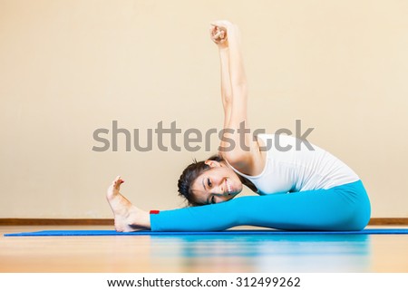 Happy and beautiful asian woman doing exercise of yoga indoor at home. She looking at camera and smiling. Concept of a healthy lifestyle, sport and the right attitude to life