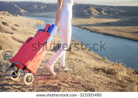 Happy asian woman carries your luggage with yoga mat. She going to play in sports or fitness exercises outdoor at mountain. Healthy lifestyles concept of body and soul