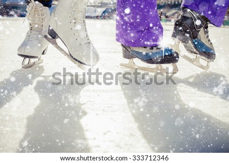 Pair is placed on ice skating. It is snowing outside. Skating close-up. Medeo, Kazakhstan