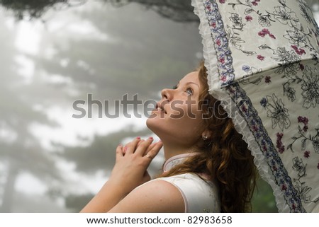 Portrait image of young women with umbrella at rain in the Chinese mountain Huangshan (yellow mountain).