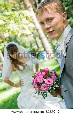 Portrait of beautiful happy couple, Just Married with Bouquet of Flower