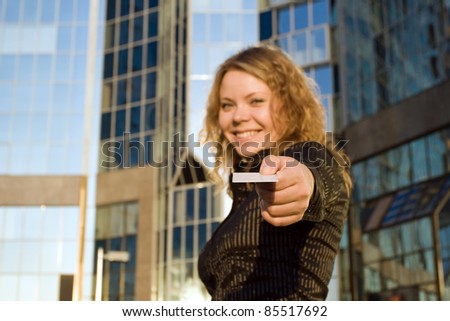 Woman giving credit card, or doing shopping and paying opposite office building