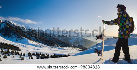 An panorama image with snowboarder with a helmet and glasses on the background of high snow-mountain Alps in Grindelwald, Swiss