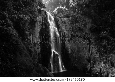 Haew Narok (chasm of hell) waterfall, Kao Yai national park, Thailand with a man beside compare size in black and white