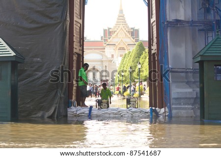 BANGKOK, THAILAND - OCTOBER 27 : An unidentified man helps bring sandbags to protect Wat Phra Kaew from rising flood waters on October 27, 2011 in Bangkok, Thailand.