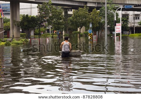 BANGKOK, THAILAND - OCTOBER 30 :  An unidentified man wading through the flood after the monsoon rain on October 30,2011  Bangkok, Thailand.