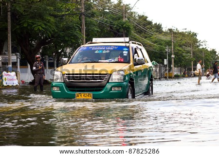 BANGKOK, THAILAND - OCTOBER 30 : Taxi car navigating through the flood after the monsoon rain in the capital on October 30,2011  Bangkok, Thailand.