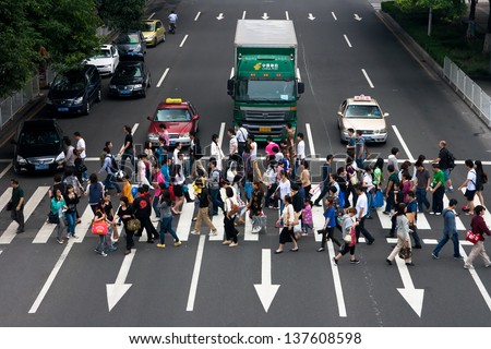 GUANGZHOU, CHINA  - MAY 2: Group of people crossing the street-upper view on May 2, 2013 in Guangzhou. China is the world\'s most populous country,Population over 1.3 billion.