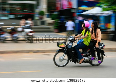 SIEM REAP, CAMBODIA - SEP 10:Girl riding a motorcycle on Sep 10, 2012 in Siem Reap. Siem Reap is Cambodia\'s main tourist cities,World Seven Wonders of Angkor Wat in Siem Reap.