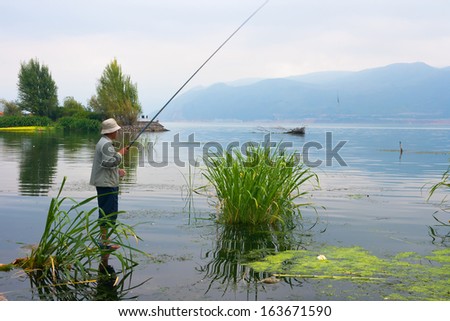 DALI, CHINA, CHINA - SEP 24: Man fishing in Erhai Lake  on Sep 24, 2011 in Dali,  Erhai Lake is second largest freshwater lake in Yunnan,Area of ??256.5 square kilometers
