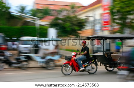 SIEM REAP, CAMBODIA - SEP 10:Man riding a motorcycle on Sep 10, 2012 in Siem Reap. Siem Reap is Cambodia\'s main tourist cities,World Seven Wonders of Angkor Wat in Siem Reap.