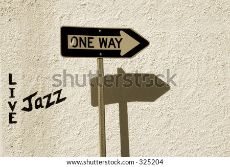 A traffic one-way sign and a Live Jazz sign painted on the wall.