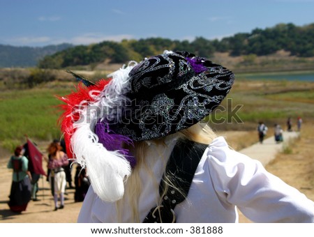 A Renaissance woman waits for a joust to occur at a pirate and Renaissance festival.