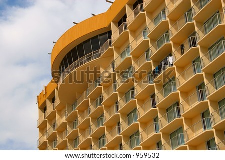 An oceanside hotel high-rise in Ventura, California, with wet suits hanging from the balconies.