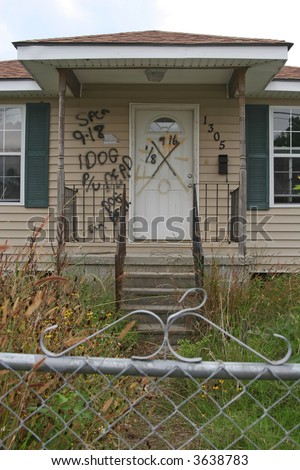 A condemned home in the 9th Ward of New Orleans, Louisiana, damaged in Hurricane Katrina. The writing indicates a dead dog was found in the home and needed to be picked up.